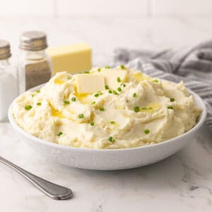 Front view of make-ahead mashed potatoes in a white serving bowl.