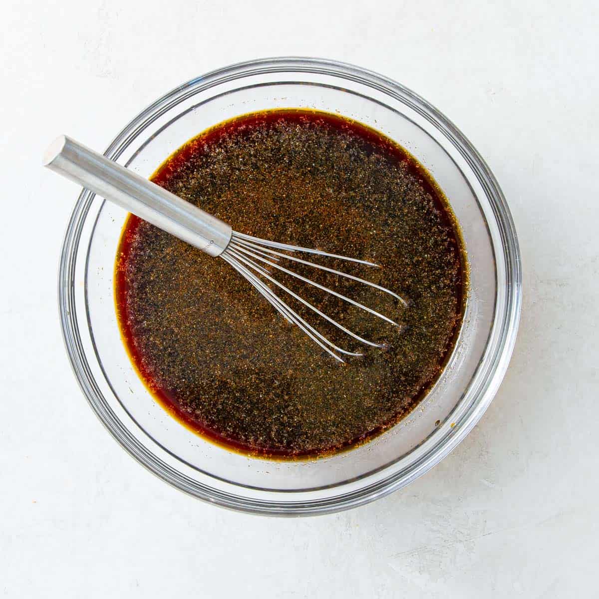 A bowl of marinade for injecting into a boneless prime rib.