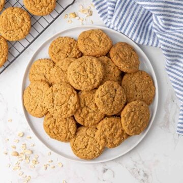 Overhead view of oatmeal peanut butter cookies on a large white plate.