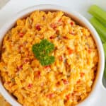 Pimento cheese spread in a white bowl. Overlay text at top of image.
