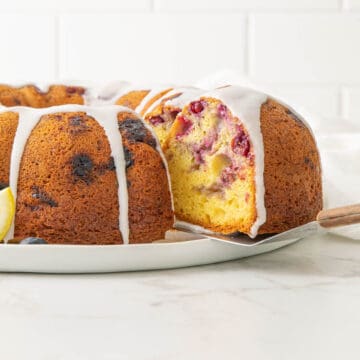 A slice of blueberry lemon Bundt cake being removed with a spatula.