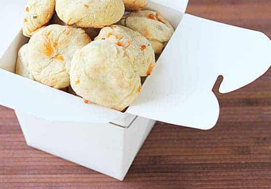 Round dog biscuits in a small white cardboard box.
