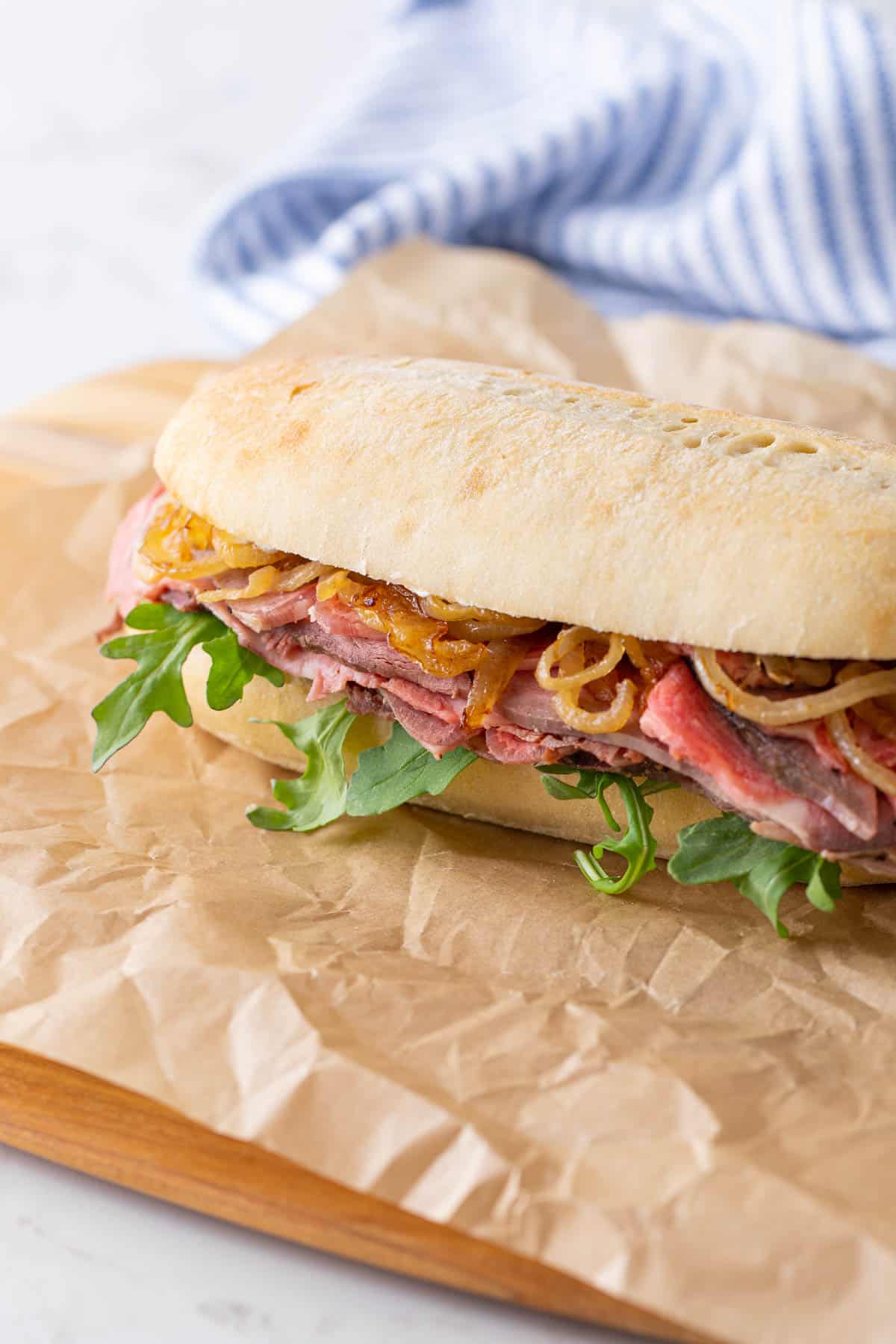 A prime rib sandwich with caramelized onions and arugula.