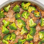 Beef and broccoli stir-fry in a sauté pan. Overlay text at top of image.