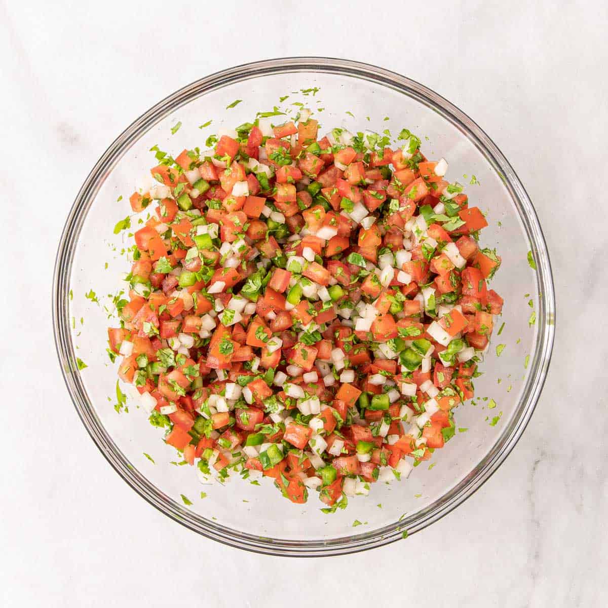 Pico de Gallo in a mixing bowl before adding lime juice and salt.