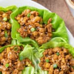 Chicken lettuce wraps on an oval platter. Overlay text at top of image.