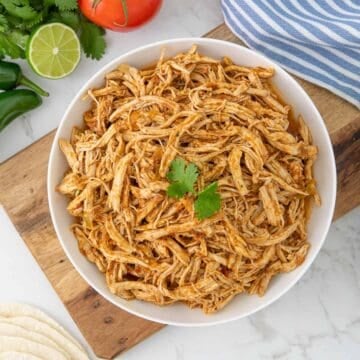 Overhead view of instant pot Mexican shredded chicken in a white serving bowl.