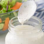 A spoon is being removed from a jar of buttermilk ranch dressing. Overlay text is at top of image.