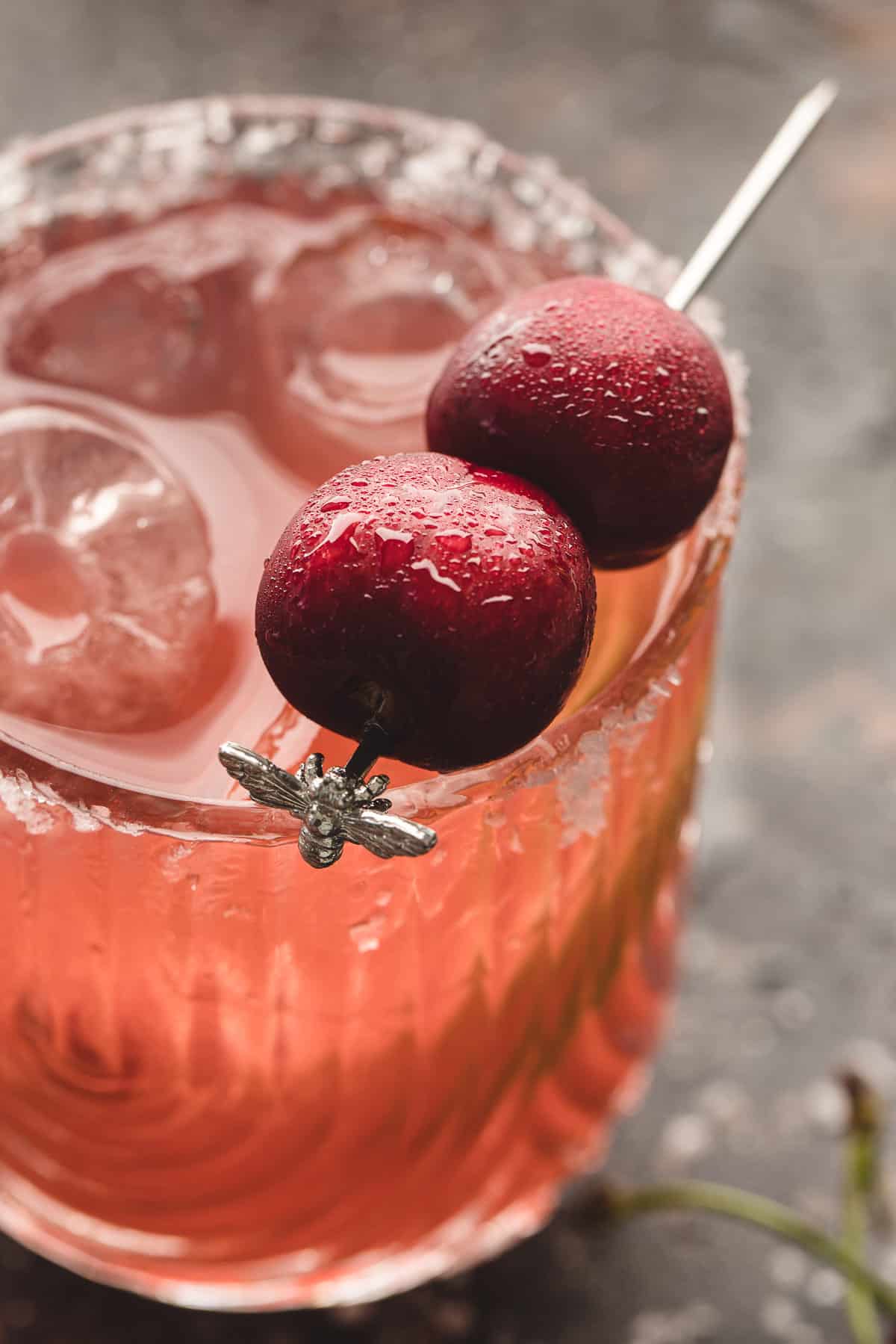 Close-up view of a cherry margarita garnished with two fresh cherries.