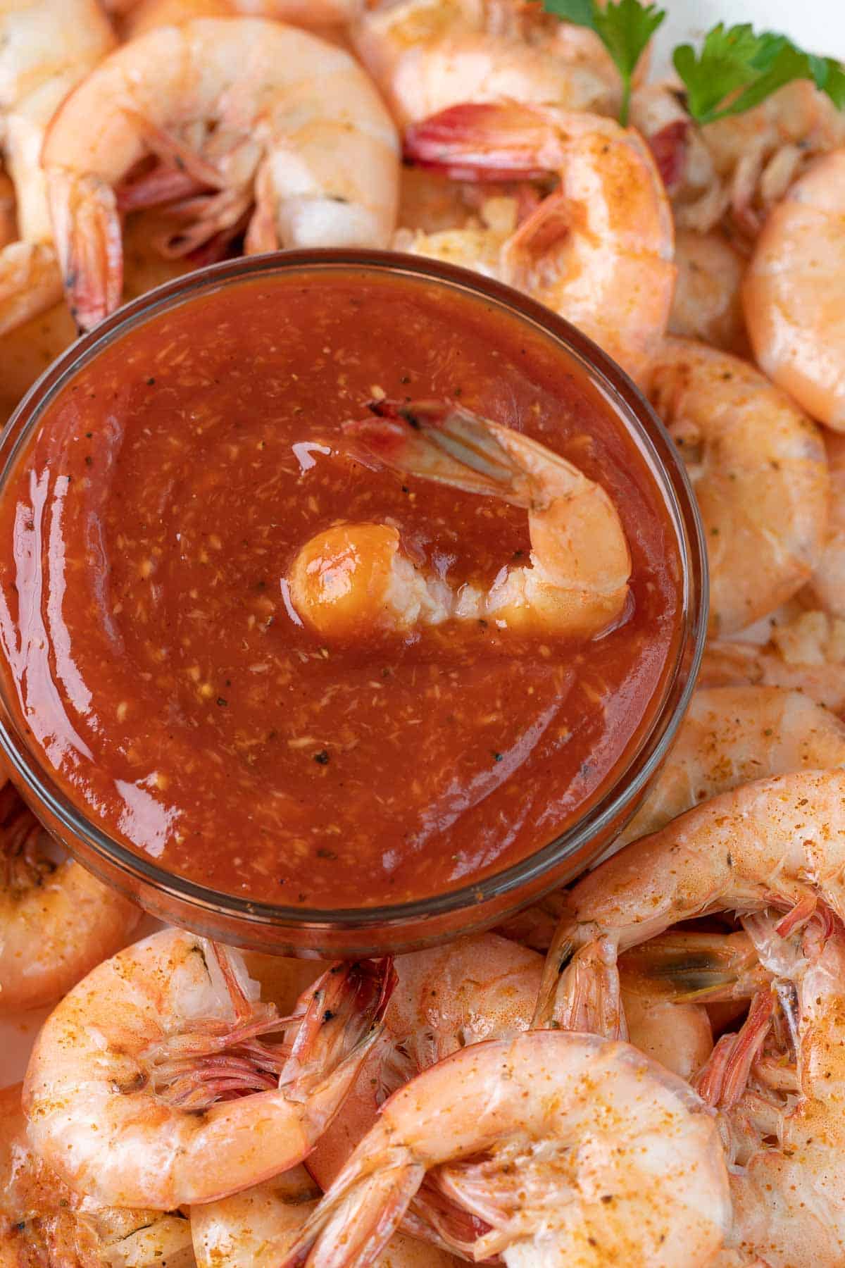 Overhead closeup view of a shrimp in a bowl of homemade cocktail sauce.