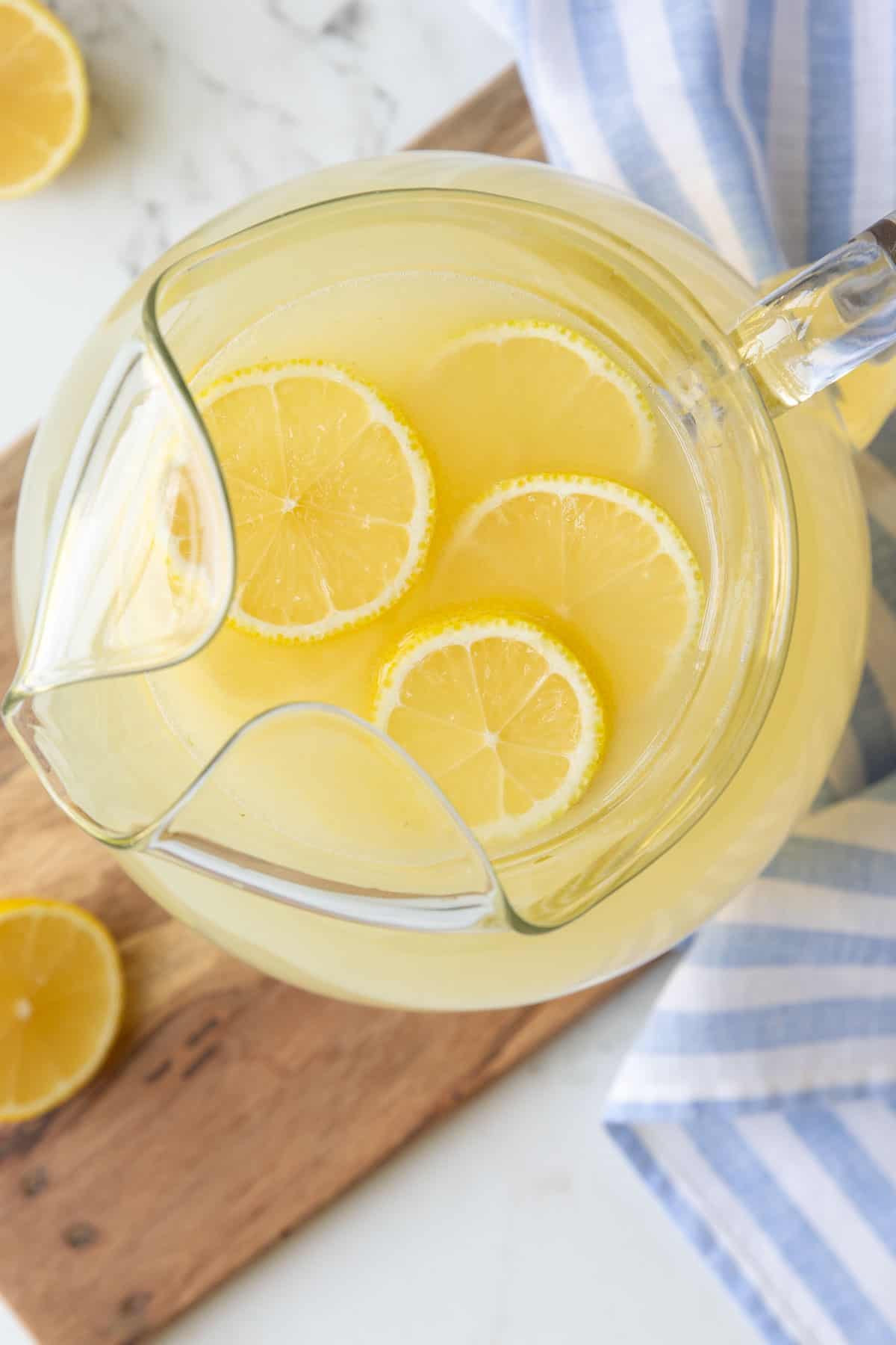 Overhead view of a pitcher of homemade lemonade with lemon slices.