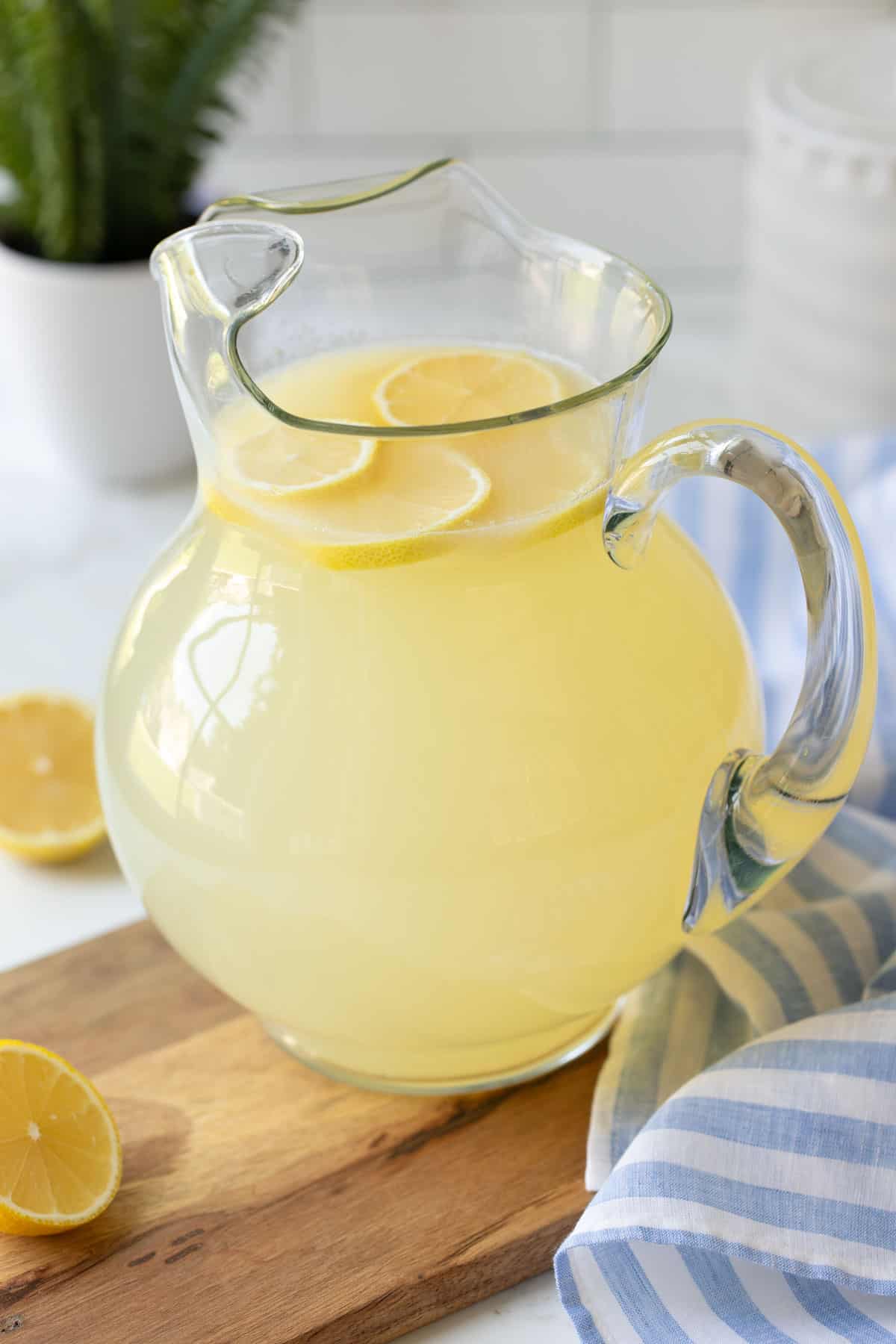 Angled view of a glass pitcher of homemade lemonade.