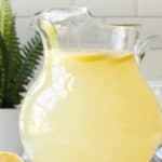 Front view of a glass pitcher of homemade lemonade. Overlay text is at the top of the image.