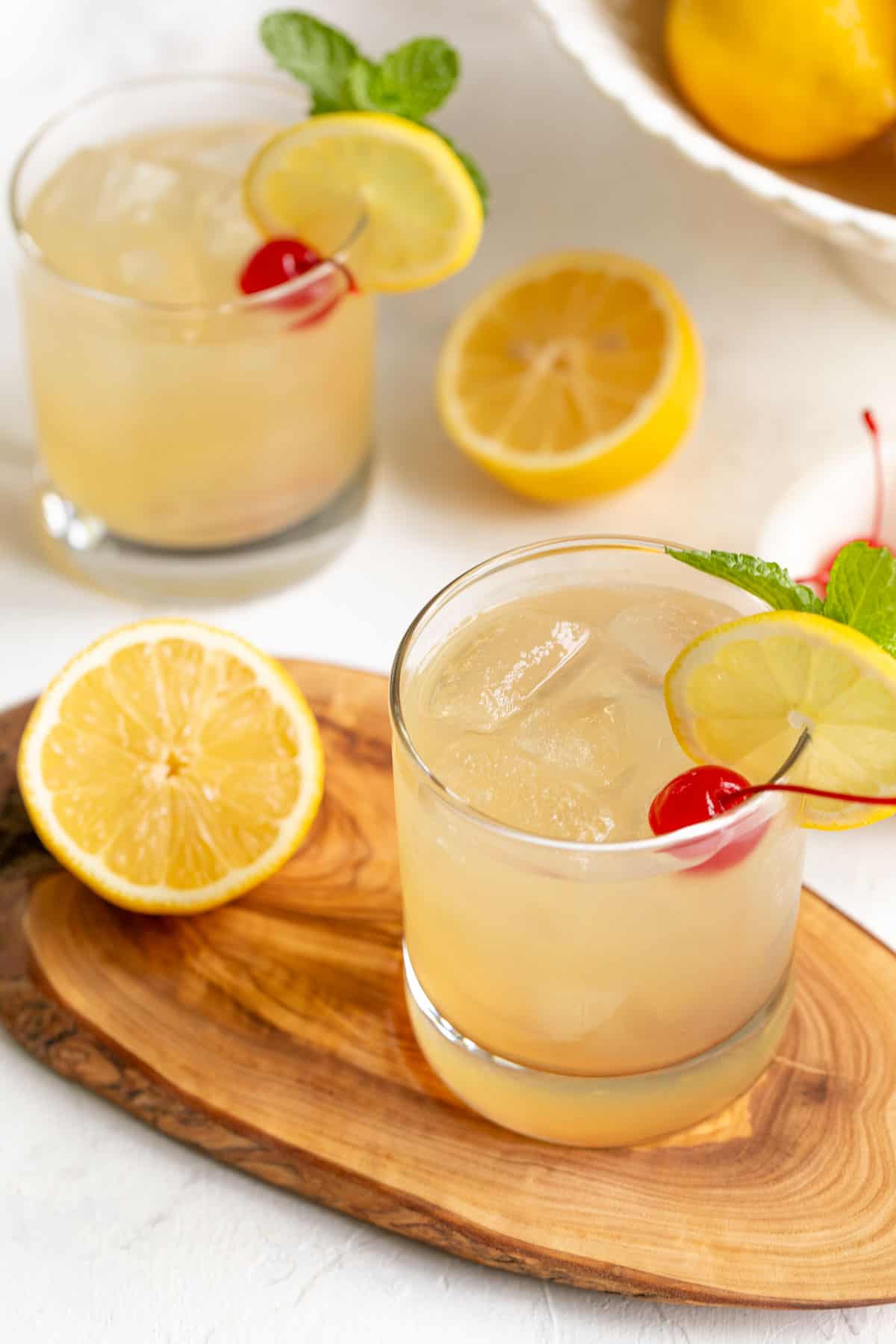 Angled view of two bourbon lemonade cocktails in whiskey glasses.