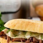 Front close-up view of a French dip sandwich. Overlay text is at the top of the image.