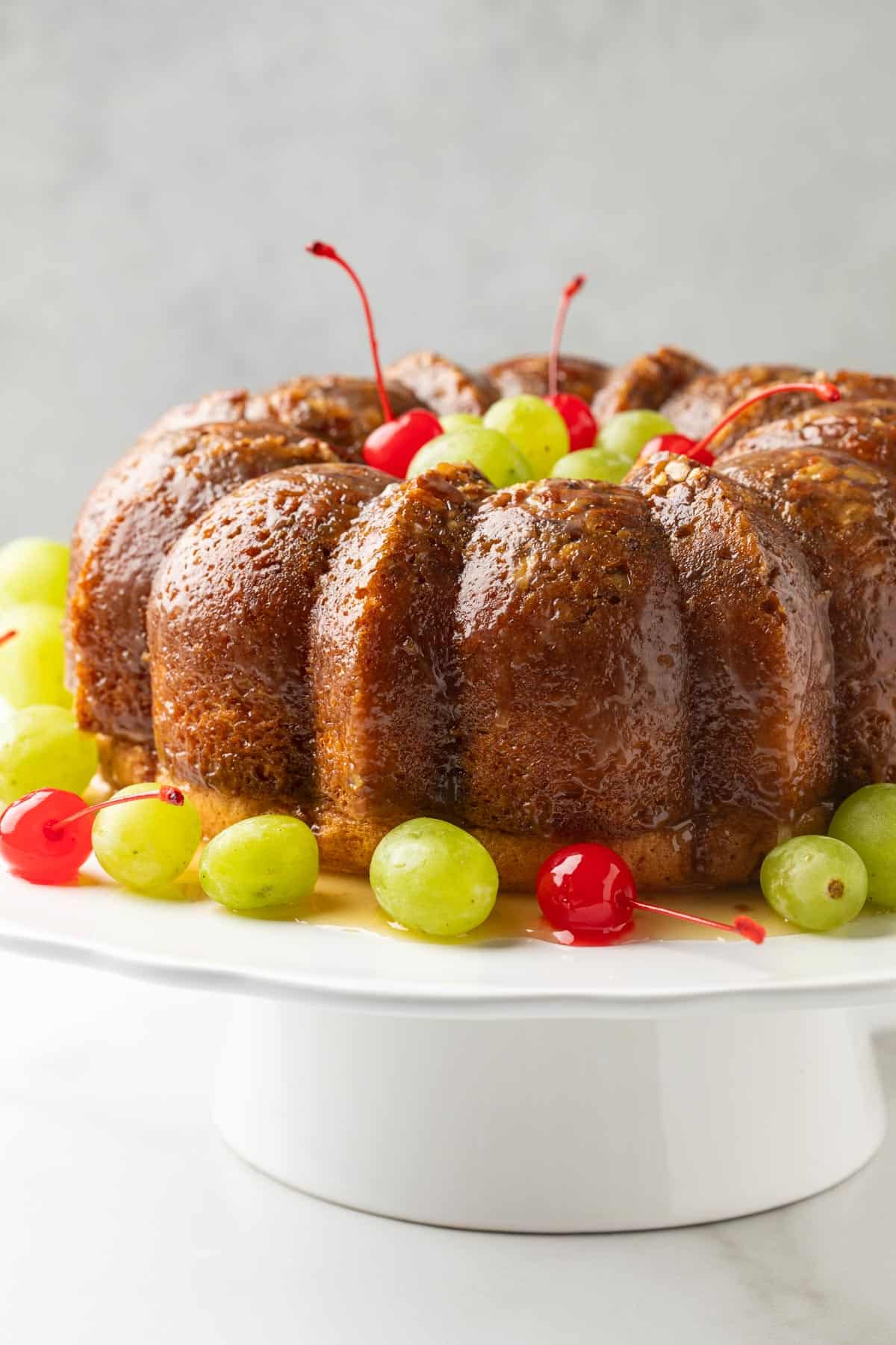 Front view of a Bacardi Rum Cake on a white cake stand.