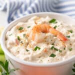 A bowl of shrimp dip on a platter. Overlay text is at the top of the image.