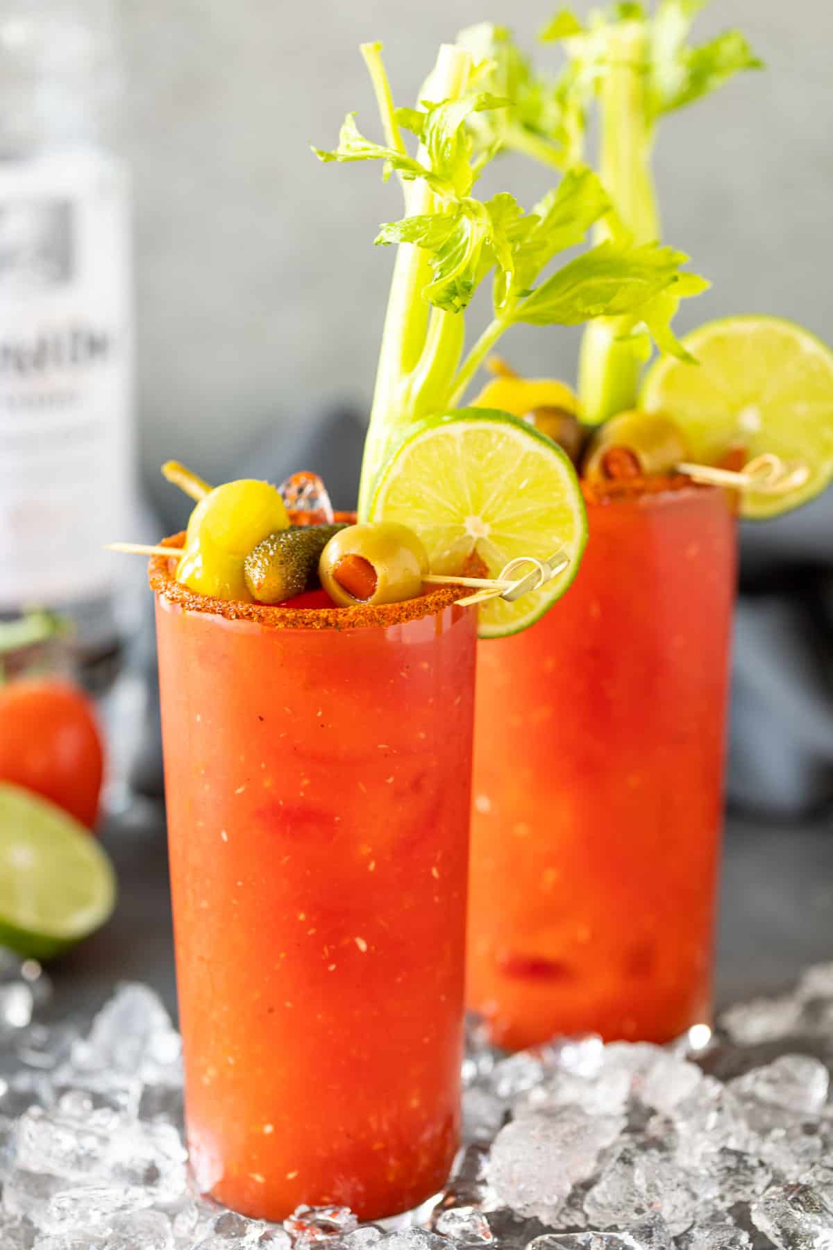 Front view of two bloody mary drinks with garnishes.