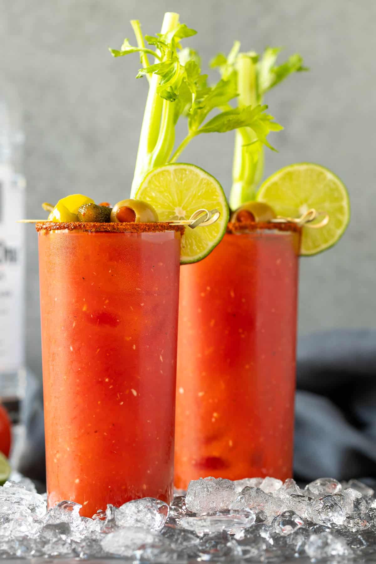 Front view of two garnished bloody mary cocktails.