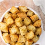 Overhead view of a bowl of croutons. Overlay text is at the top of the image.
