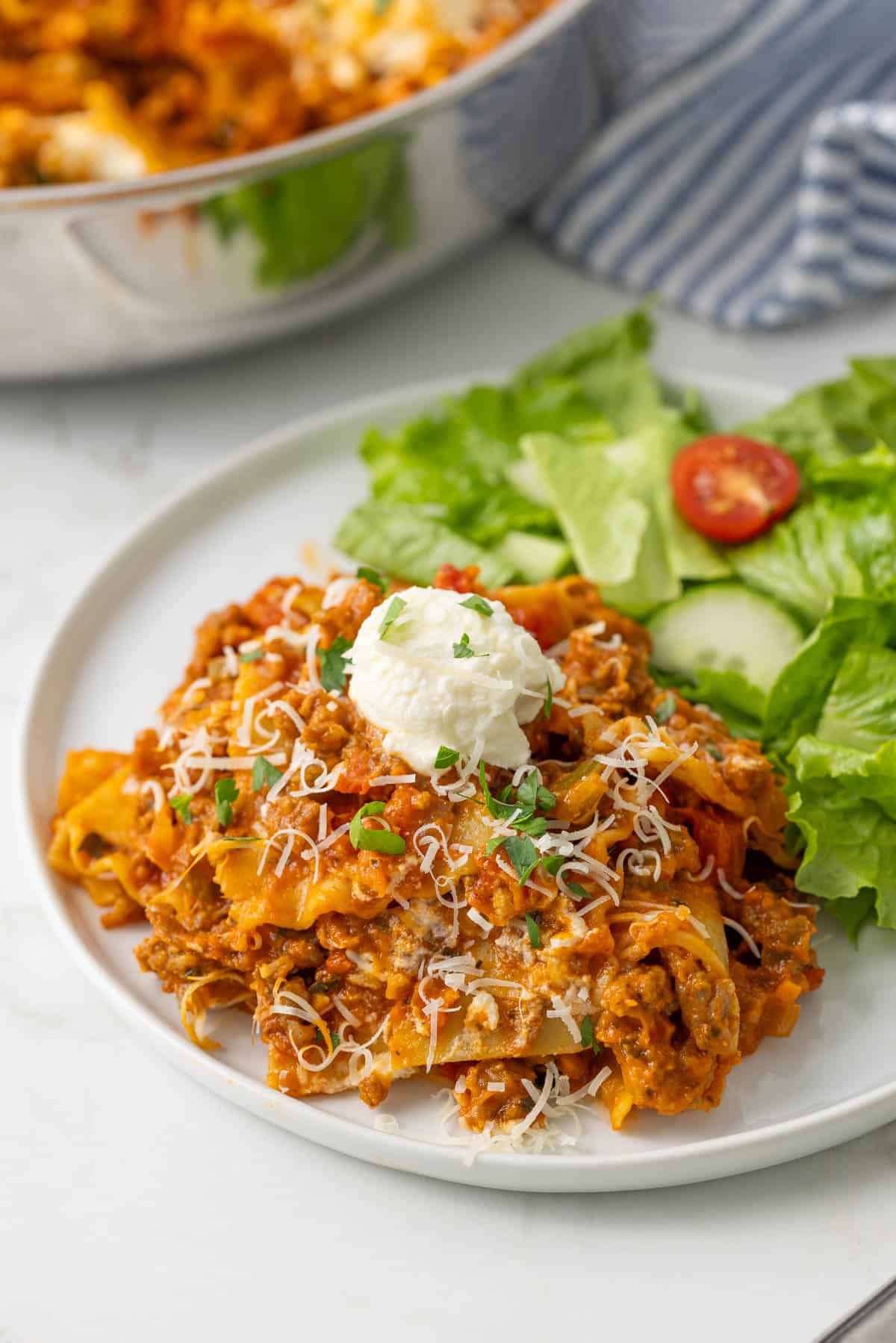 Skillet lasagna on a plate with a garden salad.