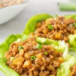 Turkey lettuce wraps on a white plate. Overlay text is at the top of the image.
