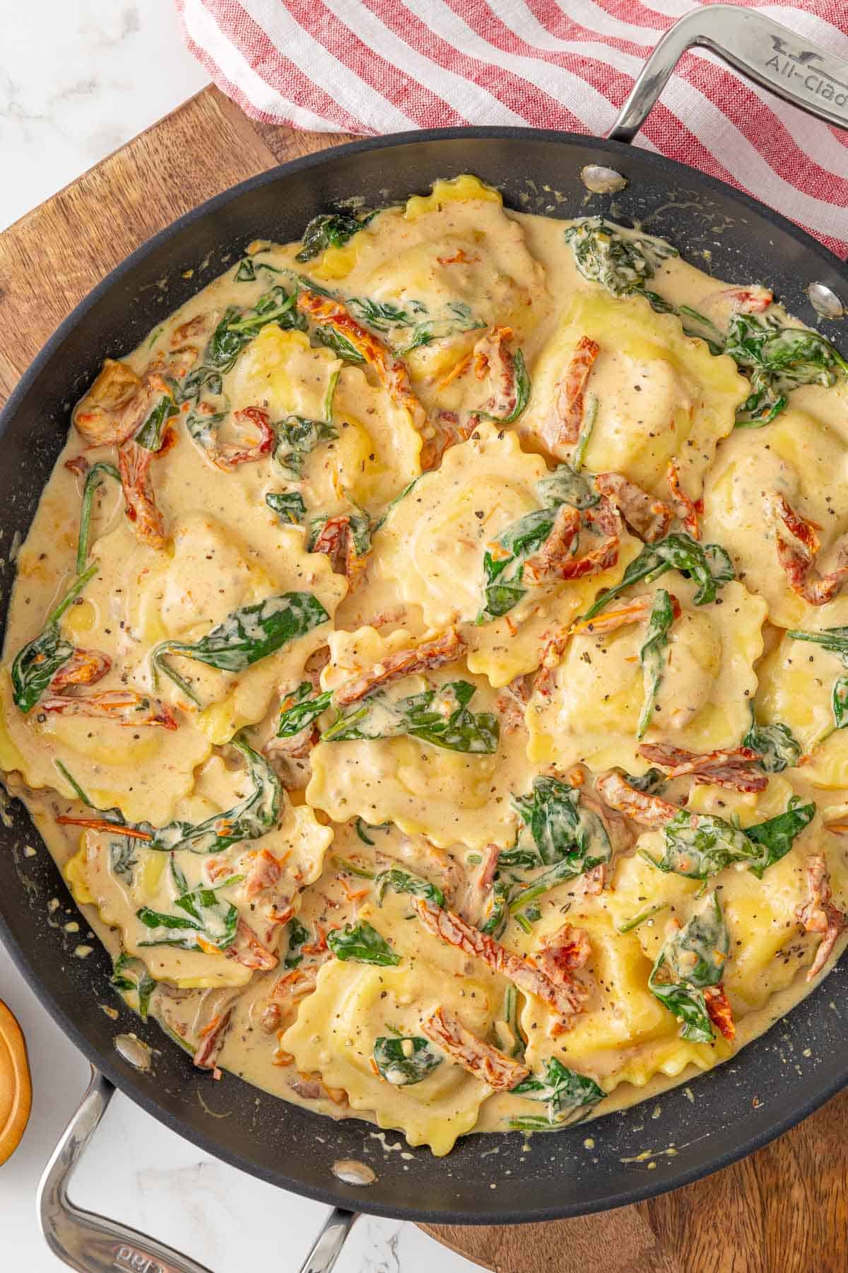 Cheese ravioli in a Tuscan cream sauce in a skillet.