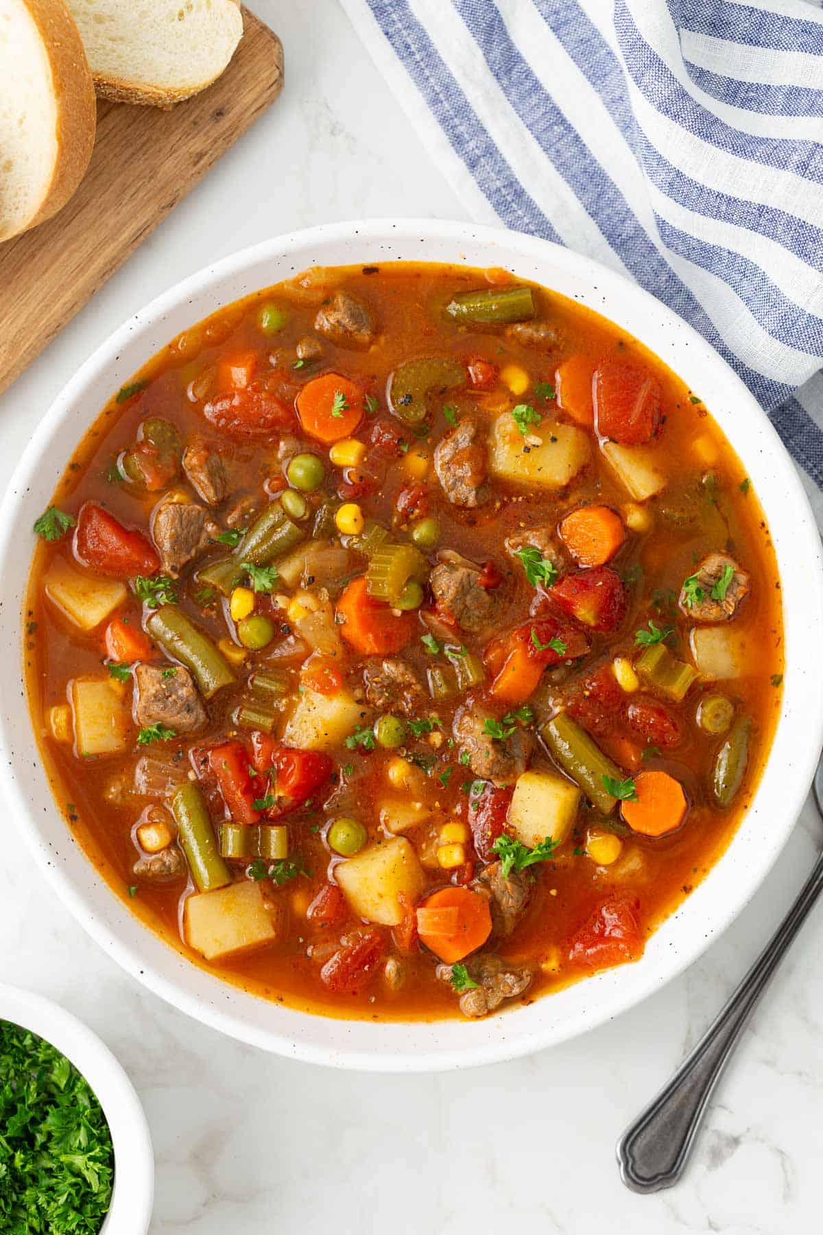 Vegetable beef soup in a white bowl.