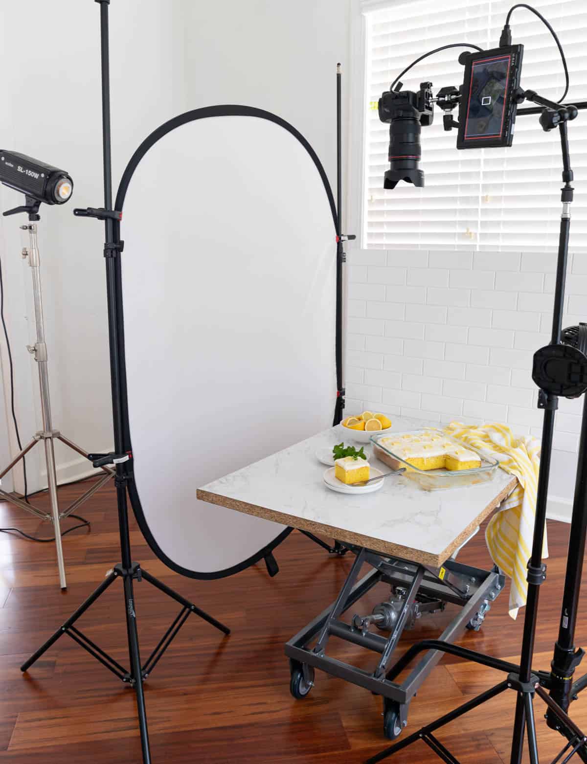 A lemon sheet cake is being photographed in a small photography studio.