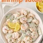 Overhead view of a bowl of cucumber shrimp salad. Overlay text is at the top of the image.
