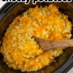A wooden spoon in a slow cooker with cheesy potatoes. Overlay text is at the top of the image.