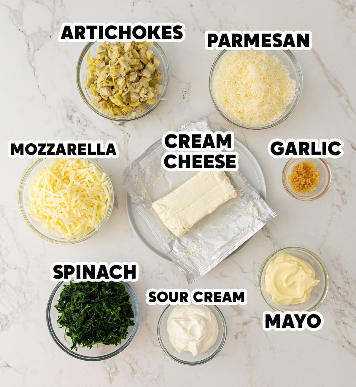 Overhead view of ingredients needed for making spinach artichoke dip with overlay text.
