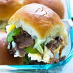 A close up view of a Philly cheesesteak slider in a baking dish.