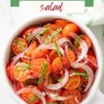 Tomato and red onion salad in a white bowl. Overlay text is at the top of the image.